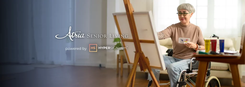 Elderly lady sitting in a wheelchair and painting on an easel